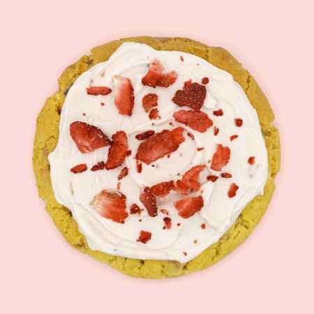 cookie con chunks di cioccolato bianco, decorato con crema allo yogurt greco alla fragola e fragole liofilizzate